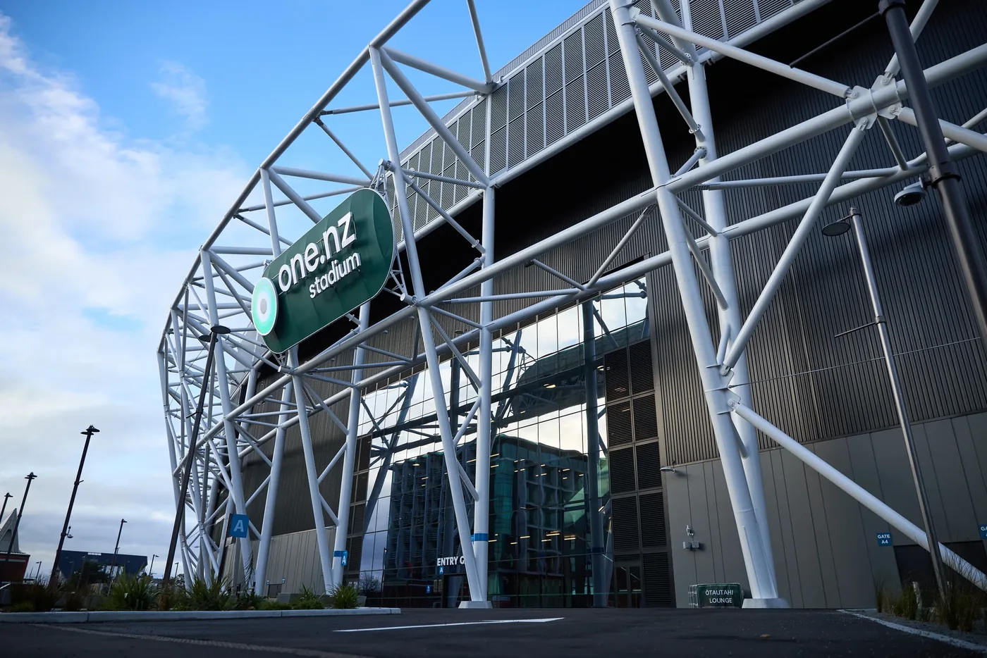 The stadium's curved white steel facade and glass frontage